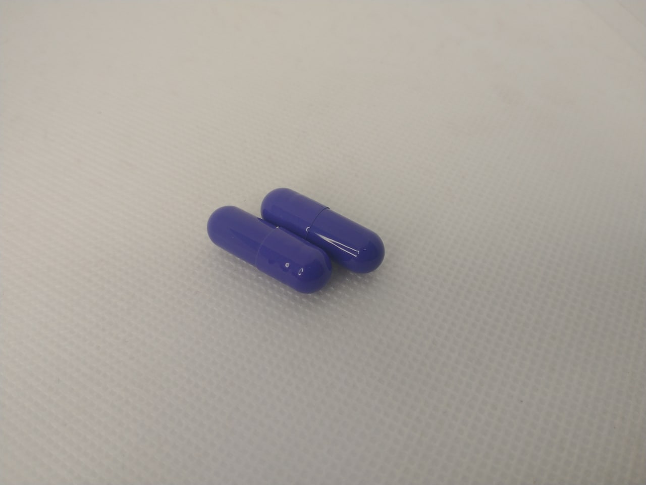 Duas cápsulas roxas do ReduPhine Caps, a dose diária recomendada
